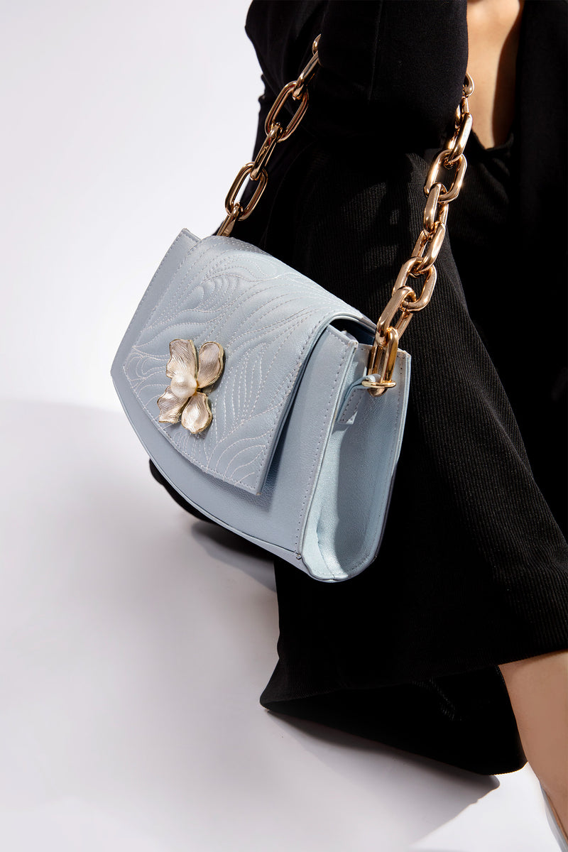 Womens leather shoulder bag in light blue colour with flower buckle and golden chain by JULKE