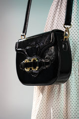 Womens leather shoulder bag in black colour with old horsebit buckle and metallic button flap by JULKE