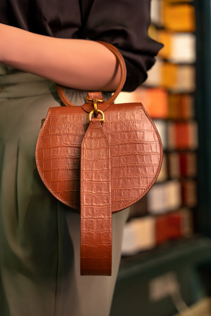 Womens leather handbag in brown colour with croc texture, round handle and wristlet by JULKE